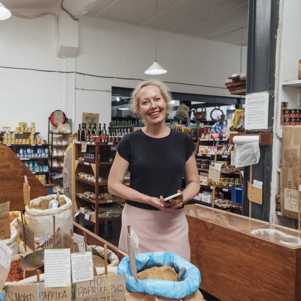 A manager in her Australian organics store smiles at the camera